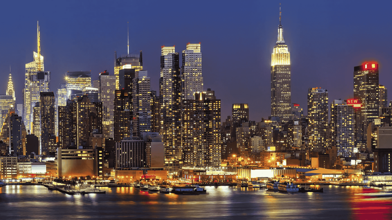 Panoramic view of New York City skyline at sunset with Empire State Building and One World Trade Center